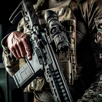 Solder shown holding an AR-15 rifle with a Trijicon IR-Patrol thermal monocular mounted to it.