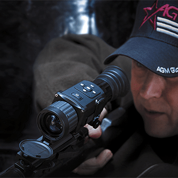 Man shown looking through a AGM Rattler TS thermal riflescope mounted to a rifle.