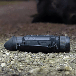 InfiRay Outdoor ZOOM dual FOV thermal monocular shown sitting on gravel.