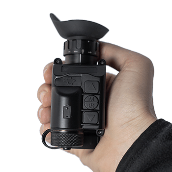 AGM StingIR handheld thermal monocular shown fitting in the palm of a man's hand.