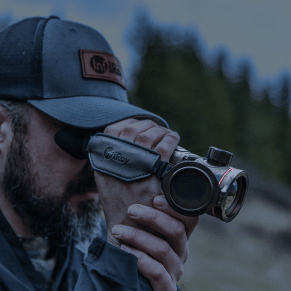 Man in a hat shown looking through a InfiRay Outdoor ZOOM ZH50 V2 thermal monocular.