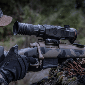 Photo showing a hunter looking through the lens of a InfiRay Outdoor RICO Mk2 LRF thermal weapon sight mounted to a bolt action rifle
